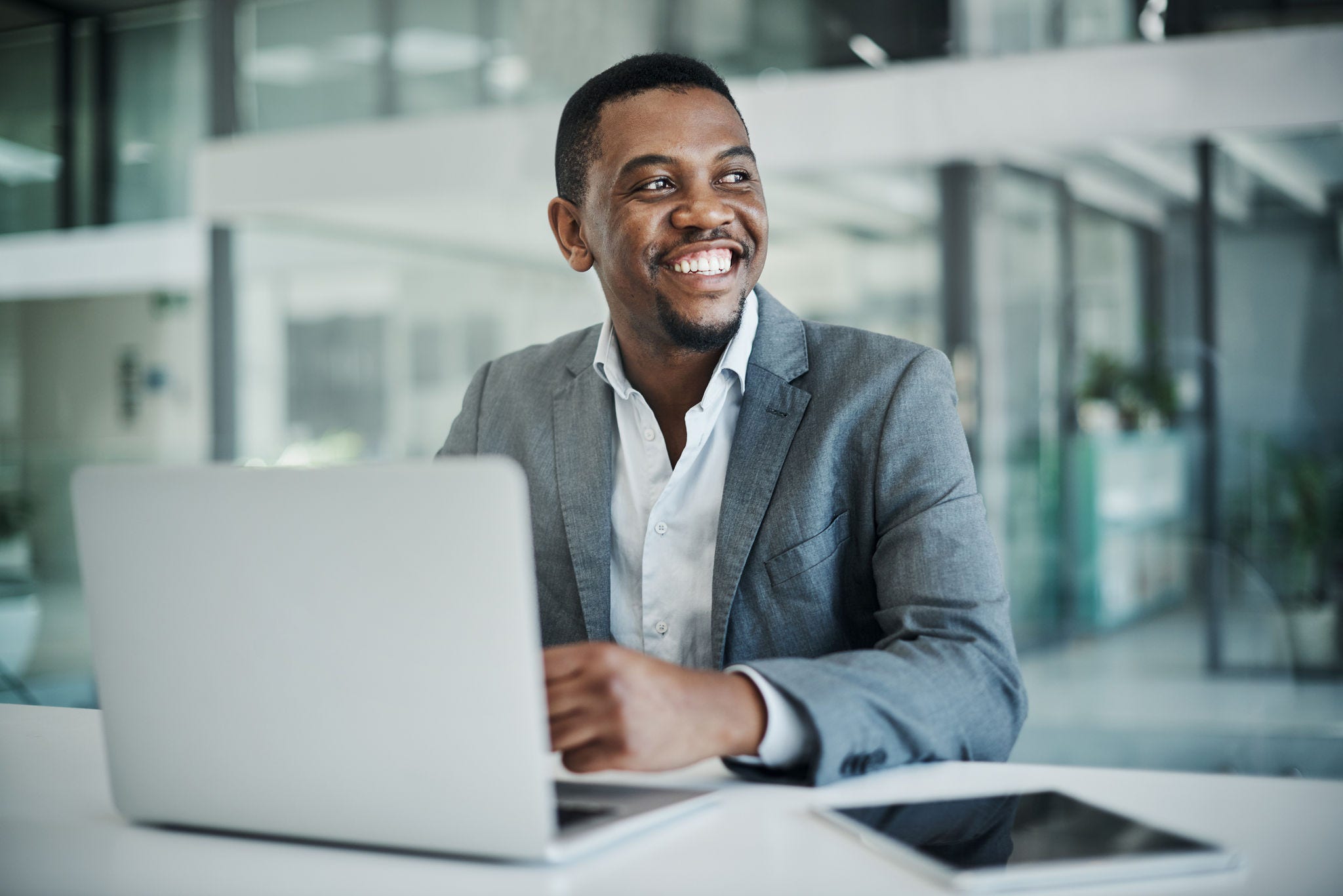 Shot of a handsome young businessman sitting alone in his office and using his laptop.