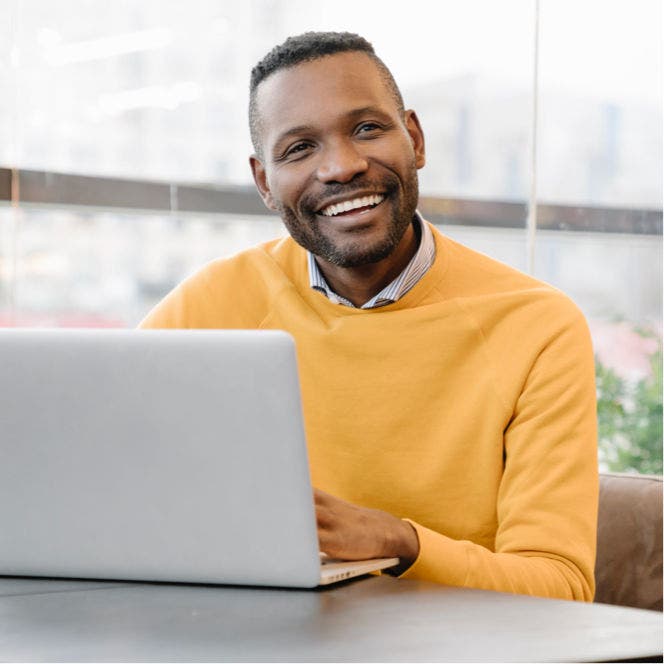 smiling man with laptop