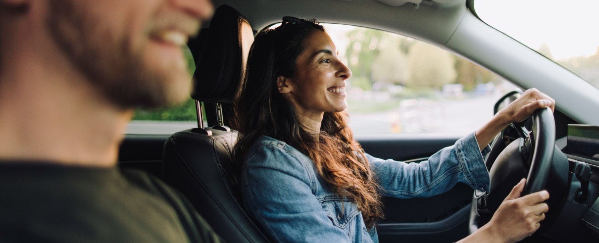man and woman driving in car