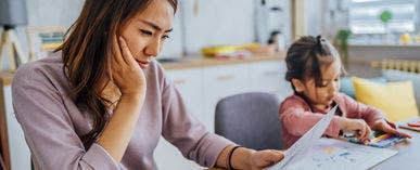 Woman reading mail and child coloring