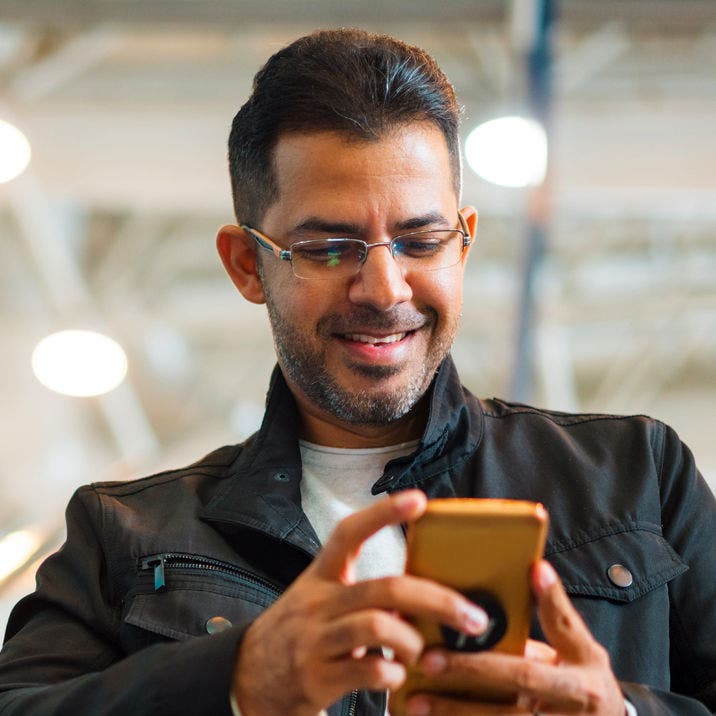 man in leather jacket using a smartphone