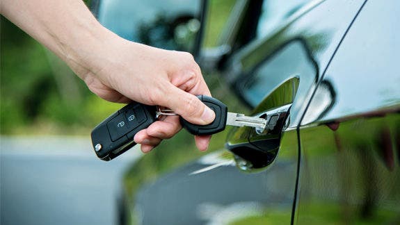 Photo of a person inserting car keys into the lock.