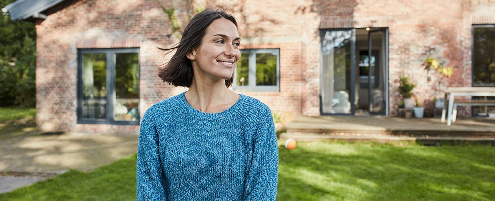 woman standing in front of  a house