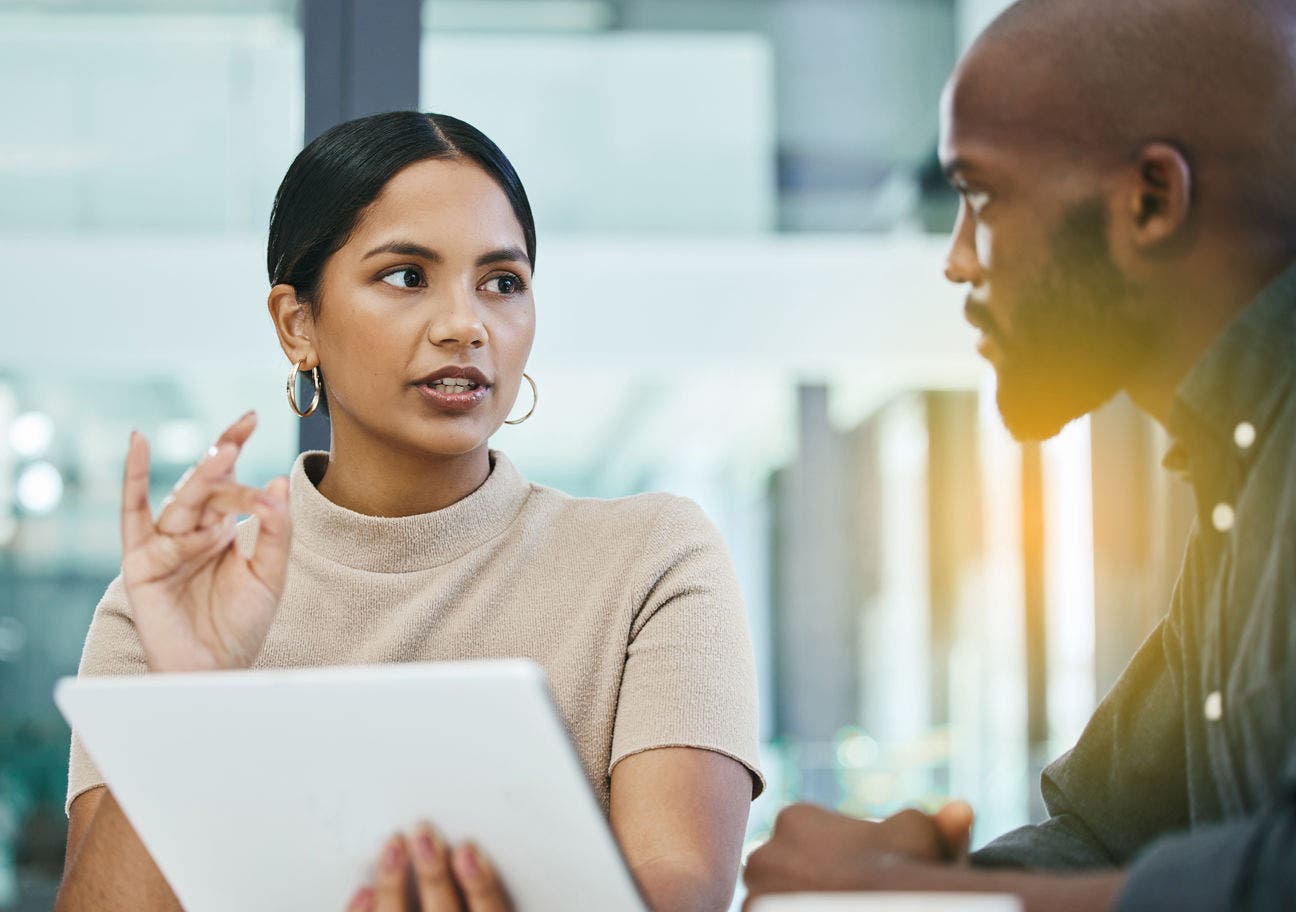 woman holding a tablet and explaining something to a man