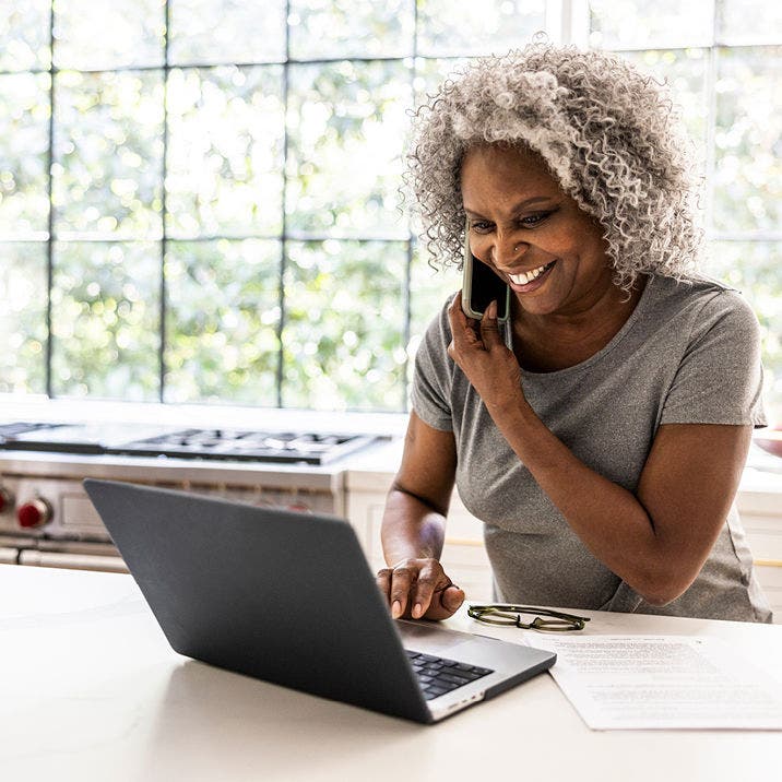 Older woman on a call while using her laptop