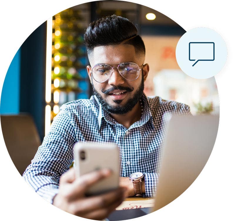 Man sitting down at table finding credit support on his cellphone