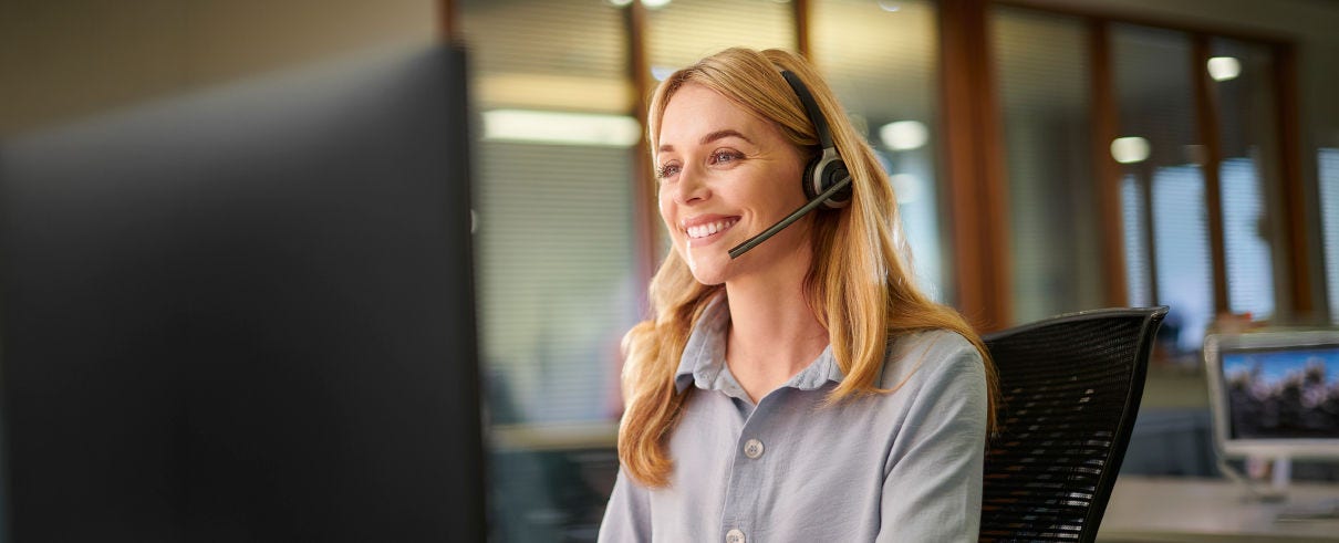 Woman on computer with headset on