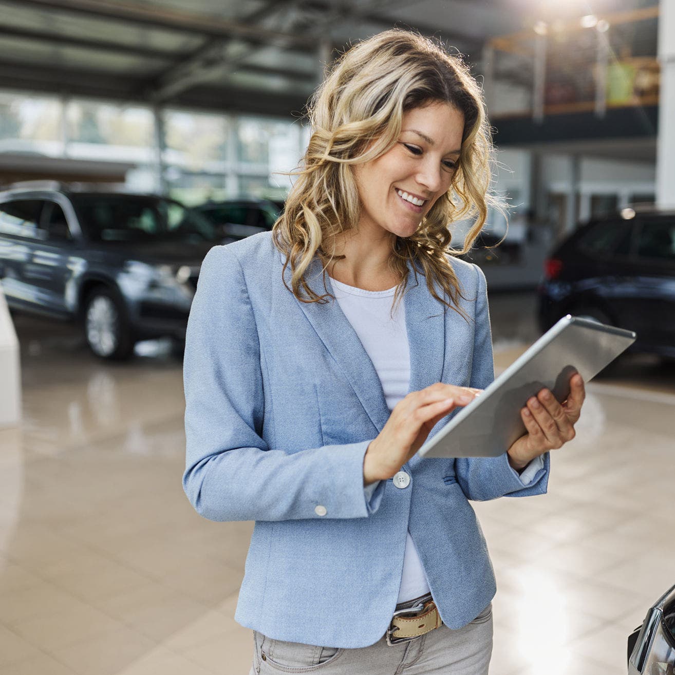 woman in car dealership using a tablet