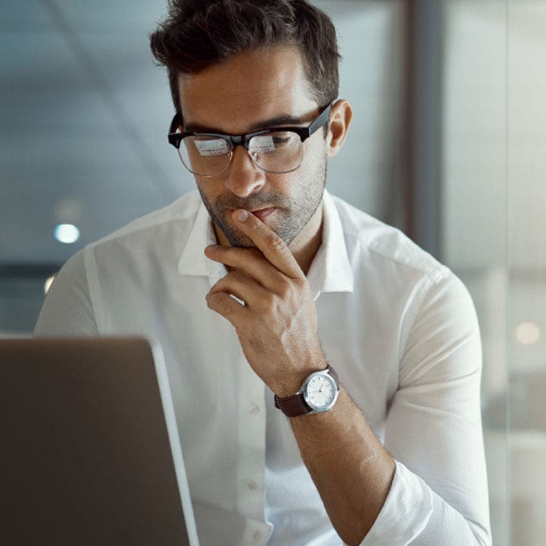person with glasses looking at laptop