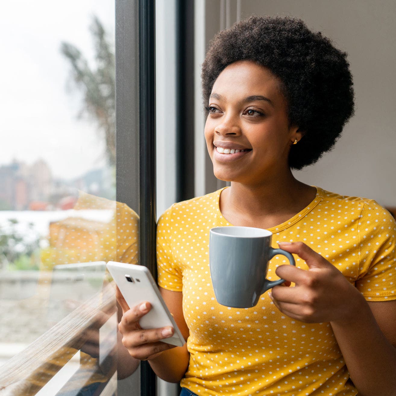 woman enjoying coffee by a window