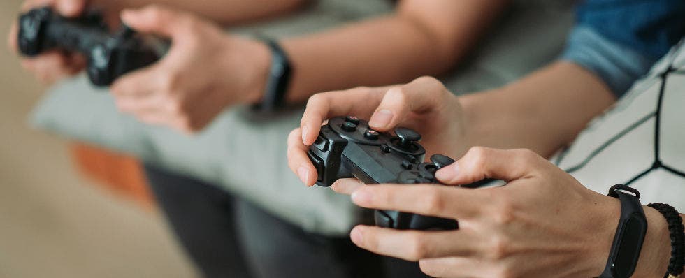 Image of two sets of hands holding video game controllers.