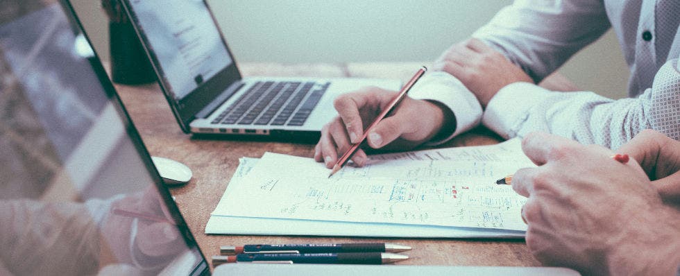 Image of business people writing on a piece of paper,.