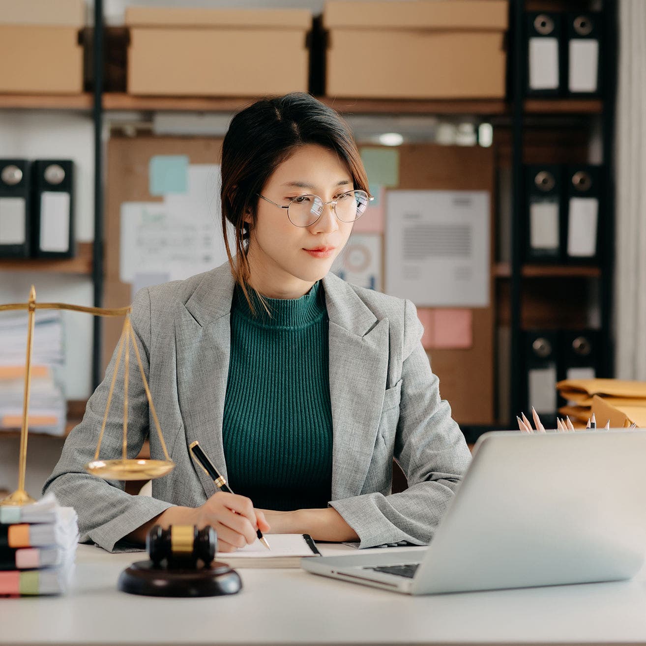 justice and law concept. asian woman lawyer working and judge in a courtroom the gavel, working with tablet and laptop and digital tablet computer on white table 