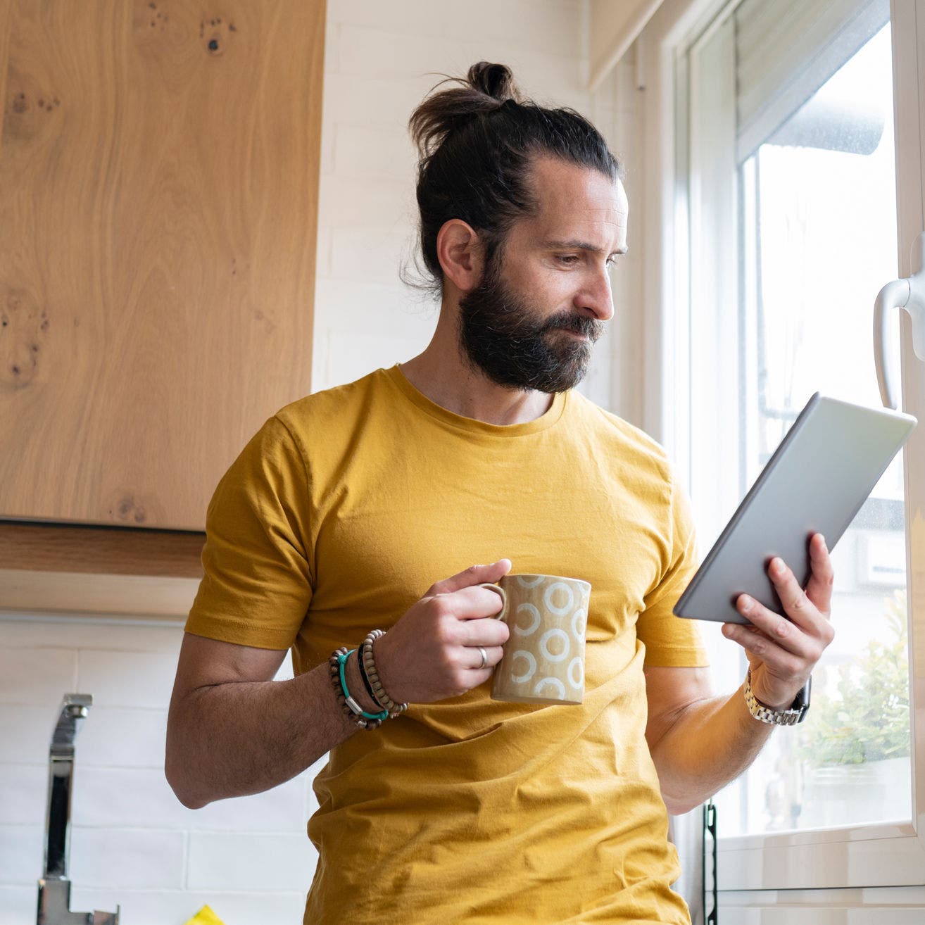 man using tablet in kitchen