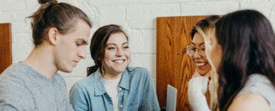 Image of people collaborating around a computer.