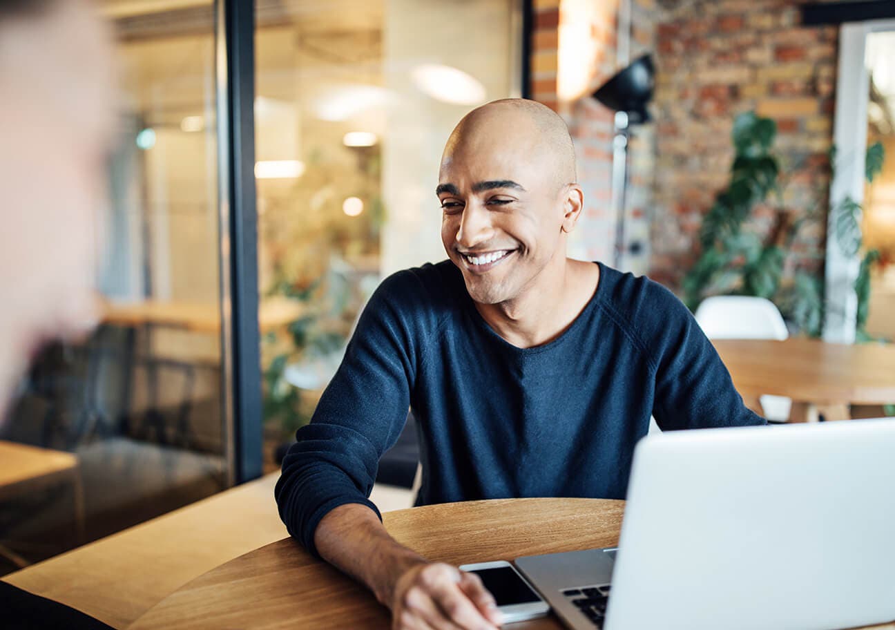man working on laptop in cafe