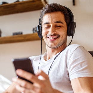 man wearing headphones and using a smartphone