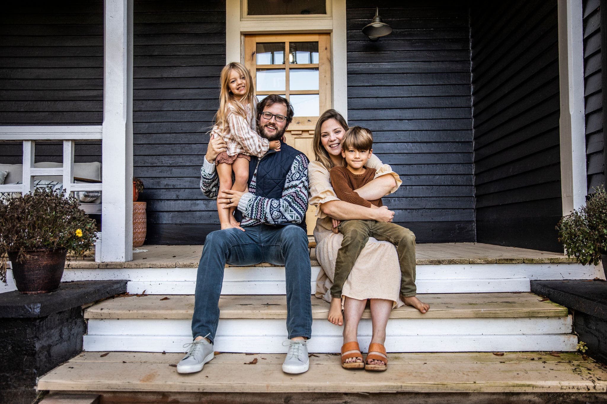 Portrait of young family in front of farmhouse