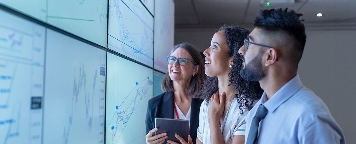 UK, York, Business people discussing charts on interactive screens