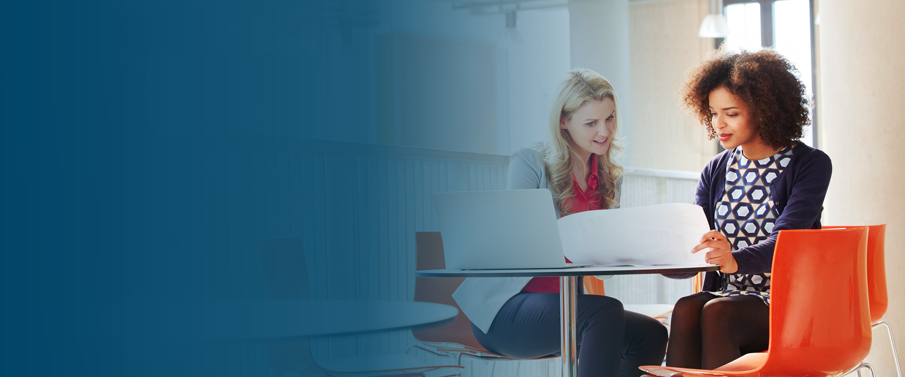 Image of two office workers sitting at a computer.
