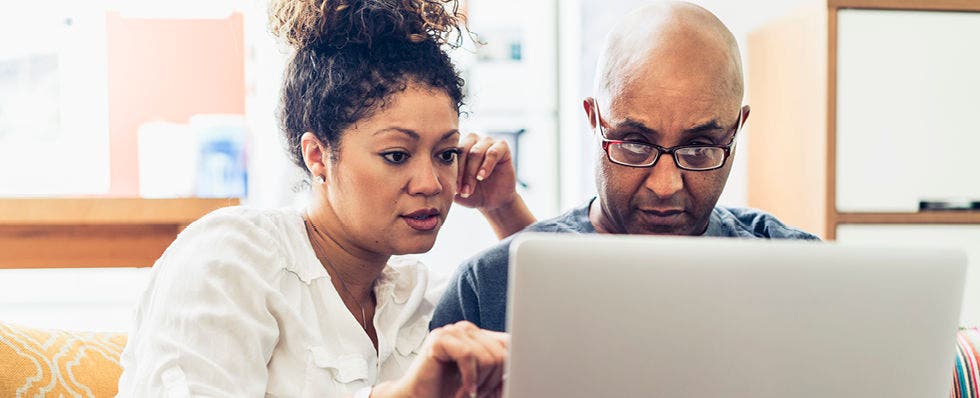 how to protect yourself from identity theft with couple looking at laptop