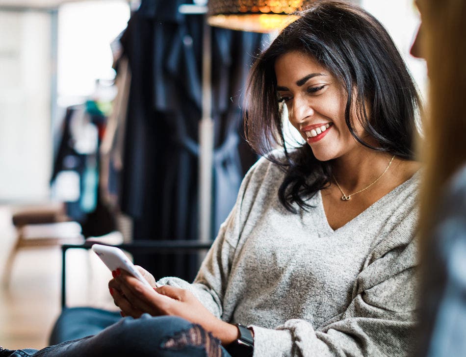 woman using smartphone in clothing store
