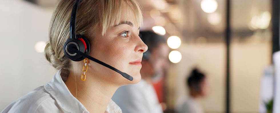 Woman with headset looking at screen