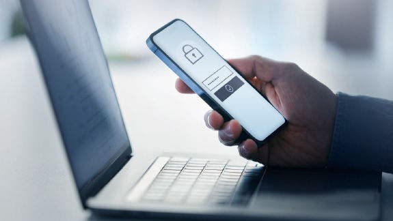 Two factor authentication screen on mobile phone with laptop