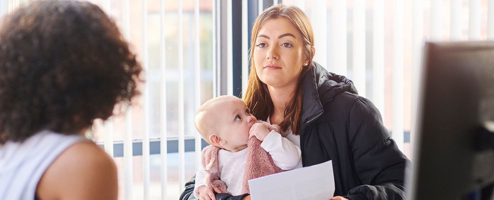 Woman and baby speaking with child support counselor