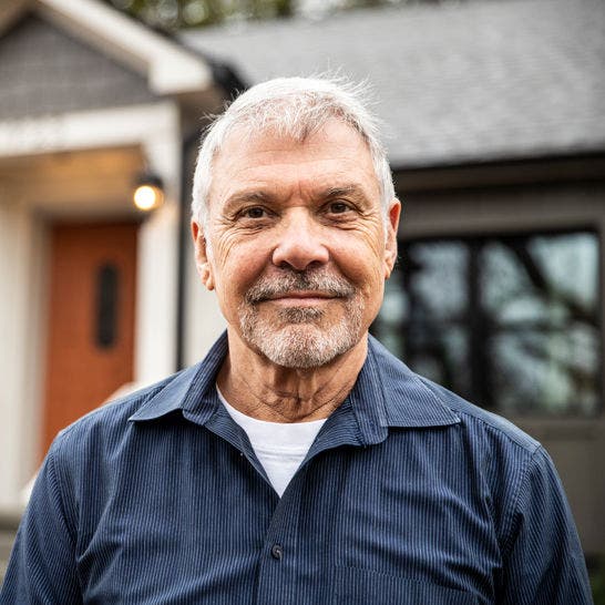 man standing in front of a house looking at the viewer