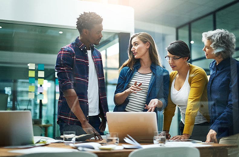Business group standing around laptop