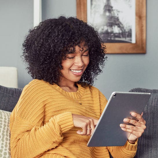 woman using a tablet on a couch