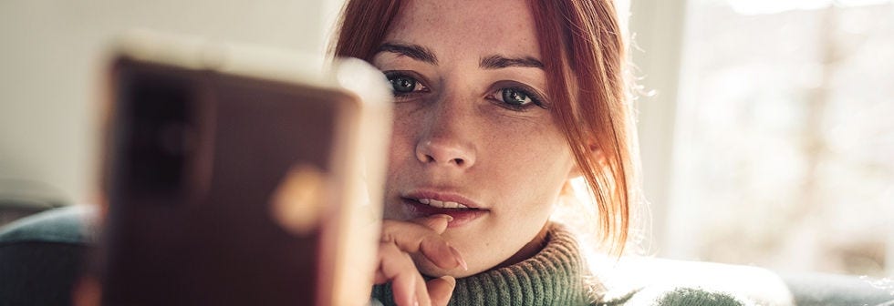 women thoughtfully looking at phone 