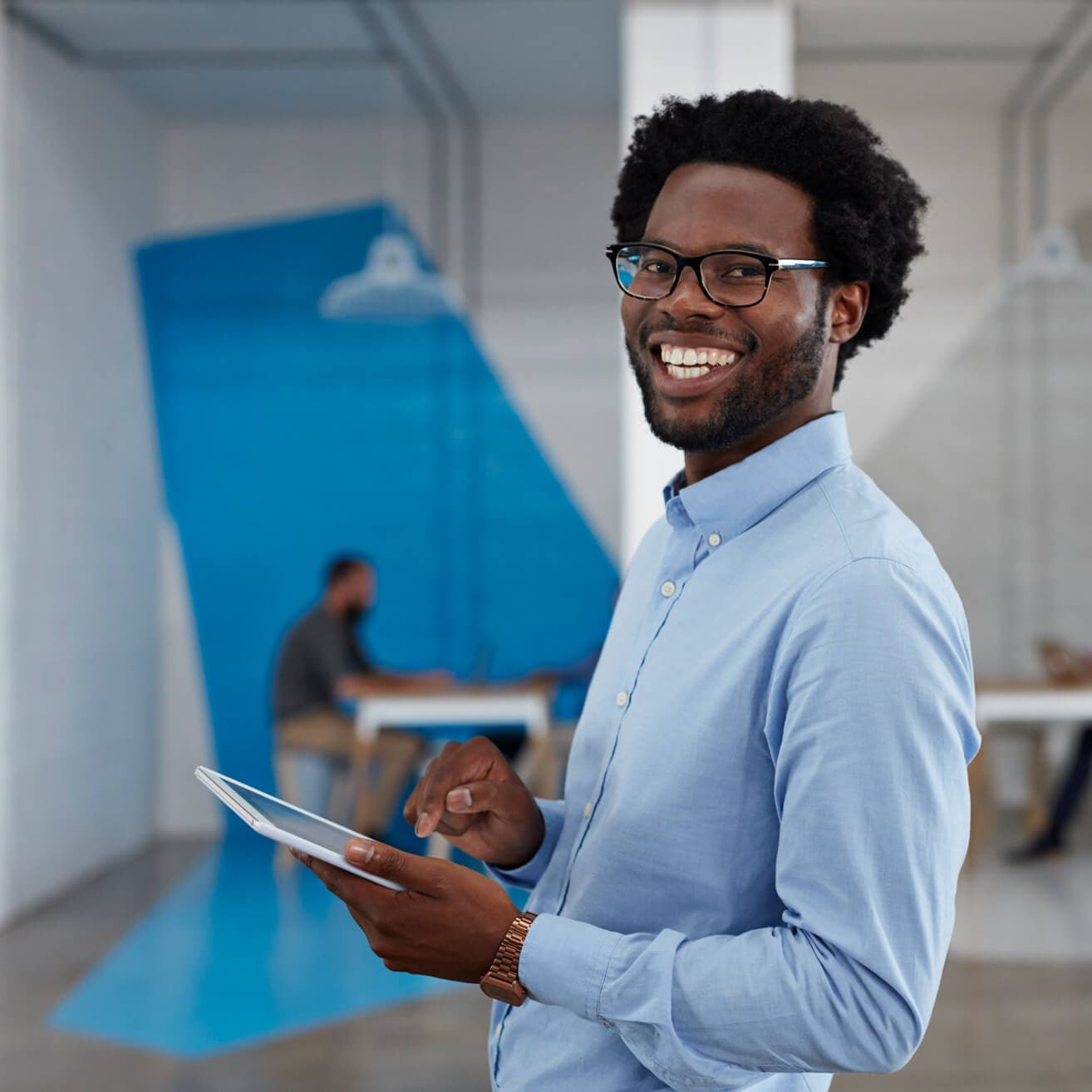 smiling man using tablet in office