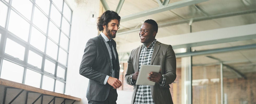 two men talking looking at tablet