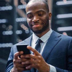 man in a business suit using a smartphone
