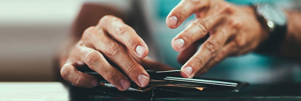 persons hands opening wallet full of credit cards