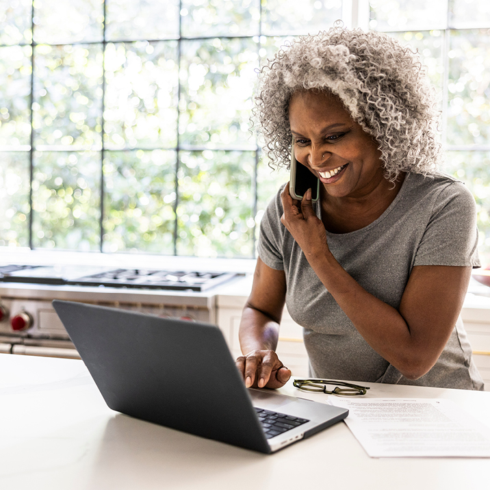 Older woman on a call while using her laptop