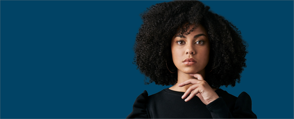 woman with curly hair blue blackdrop