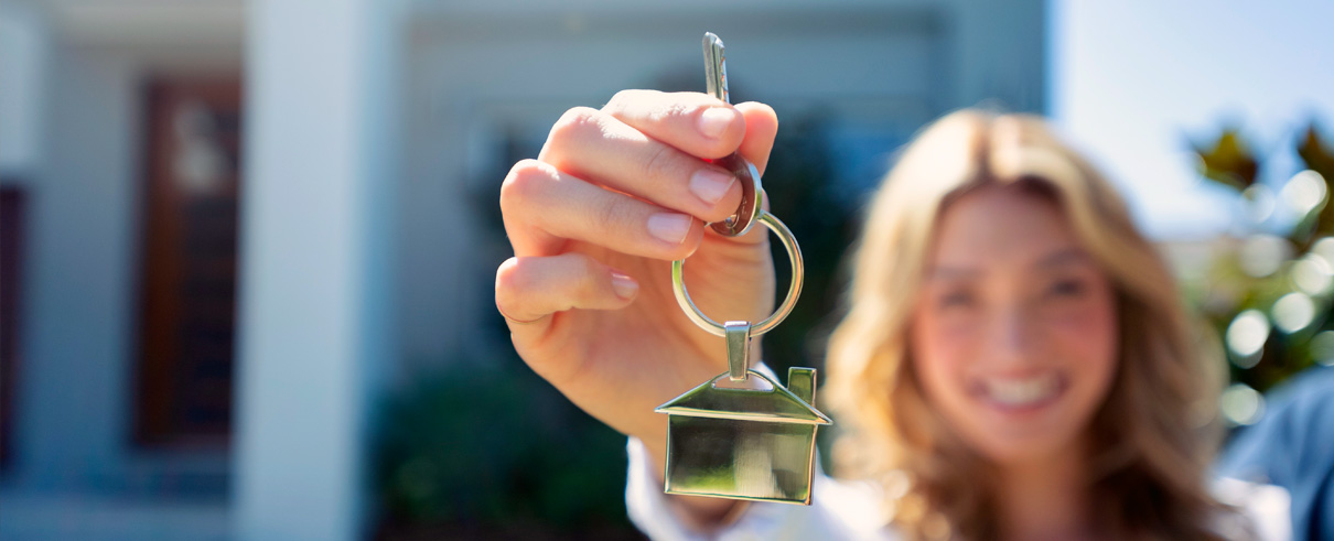 hand holding key with house on keychain