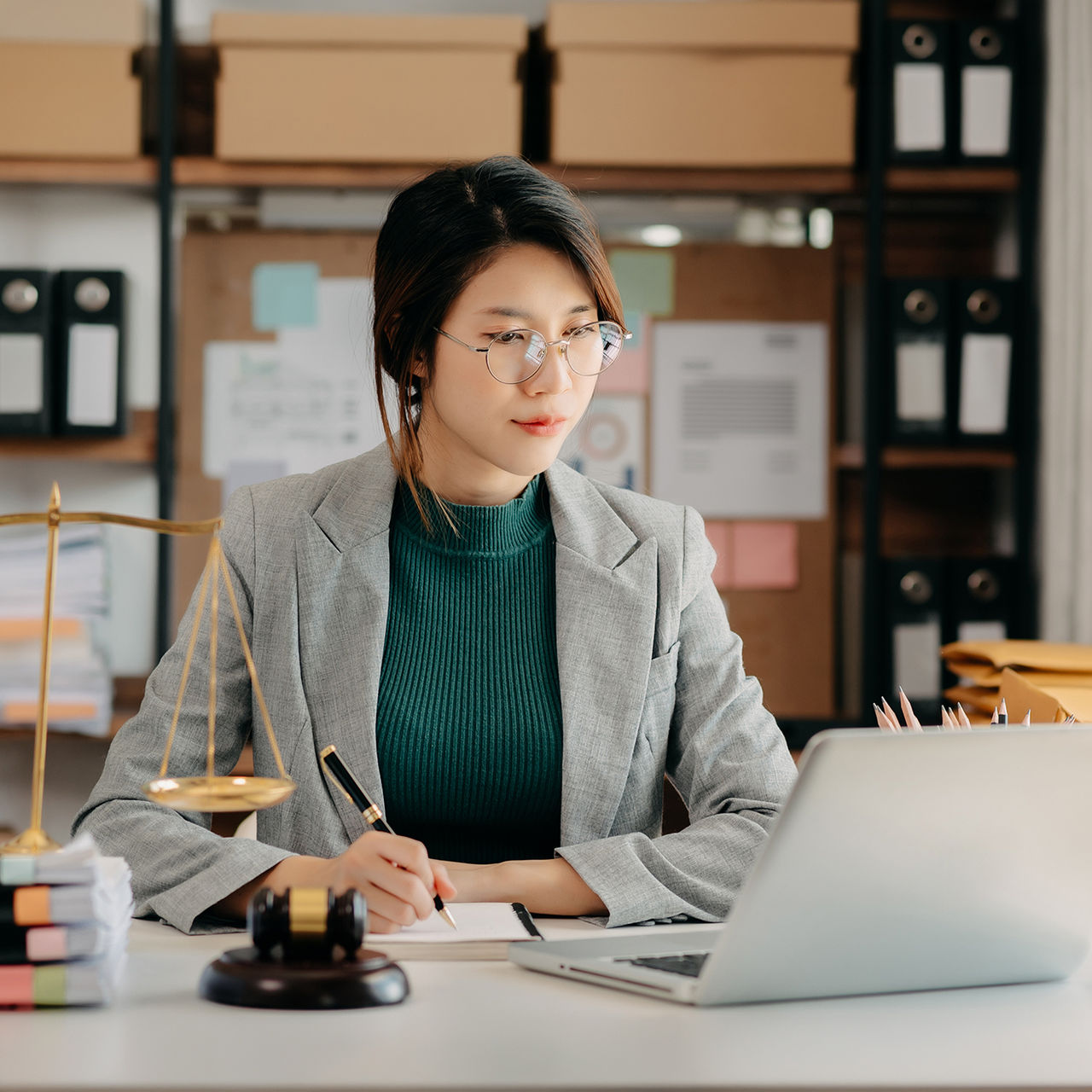 justice and law concept. asian woman lawyer working and judge in a courtroom the gavel, working with tablet and laptop and digital tablet computer on white table 