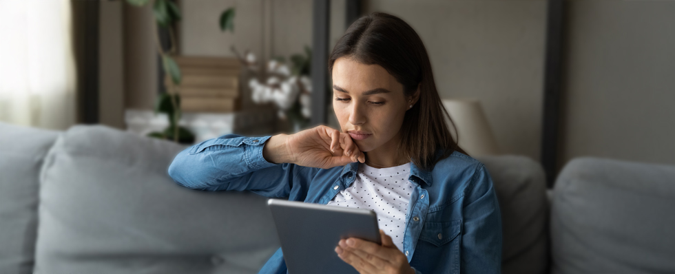 woman on couch looking at tablet
