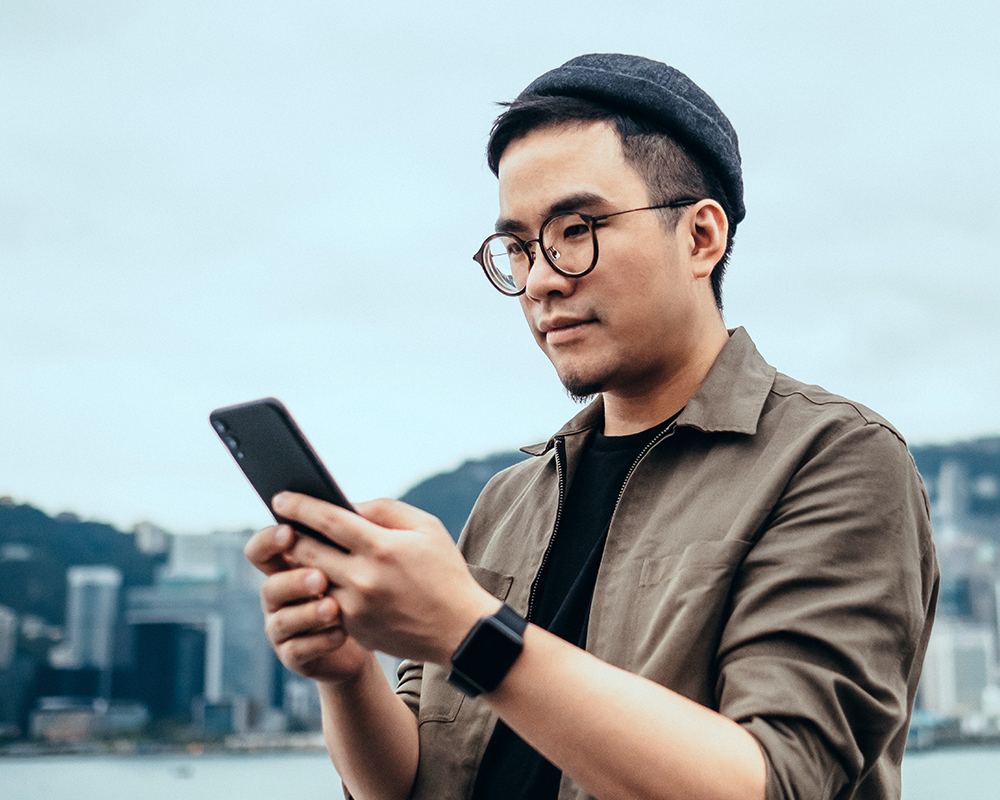 Man wearing glasses looking at mobile phone