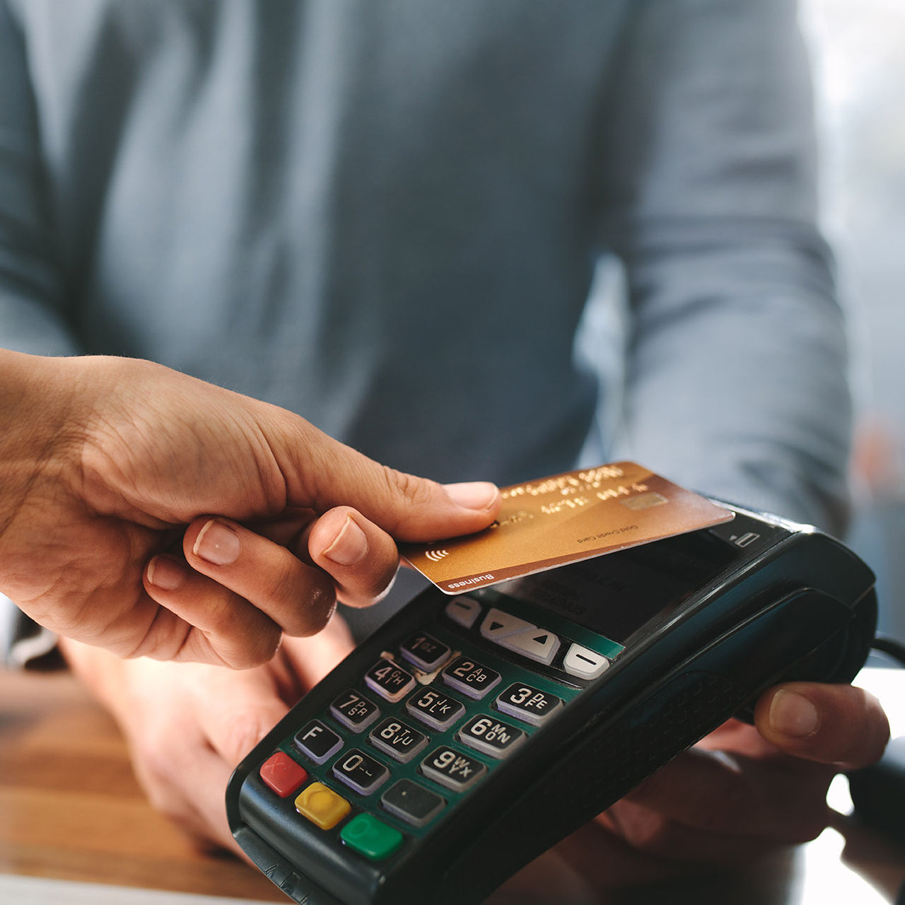 Pharmacist accepting credit card by contactless payment.  Woman purchasing products in the pharmacy. Pharmacist hands charging with credit card reader.