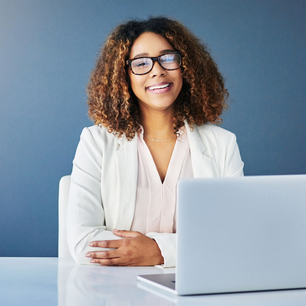 Studio shot of a young beautiful businesswoman against a blue background