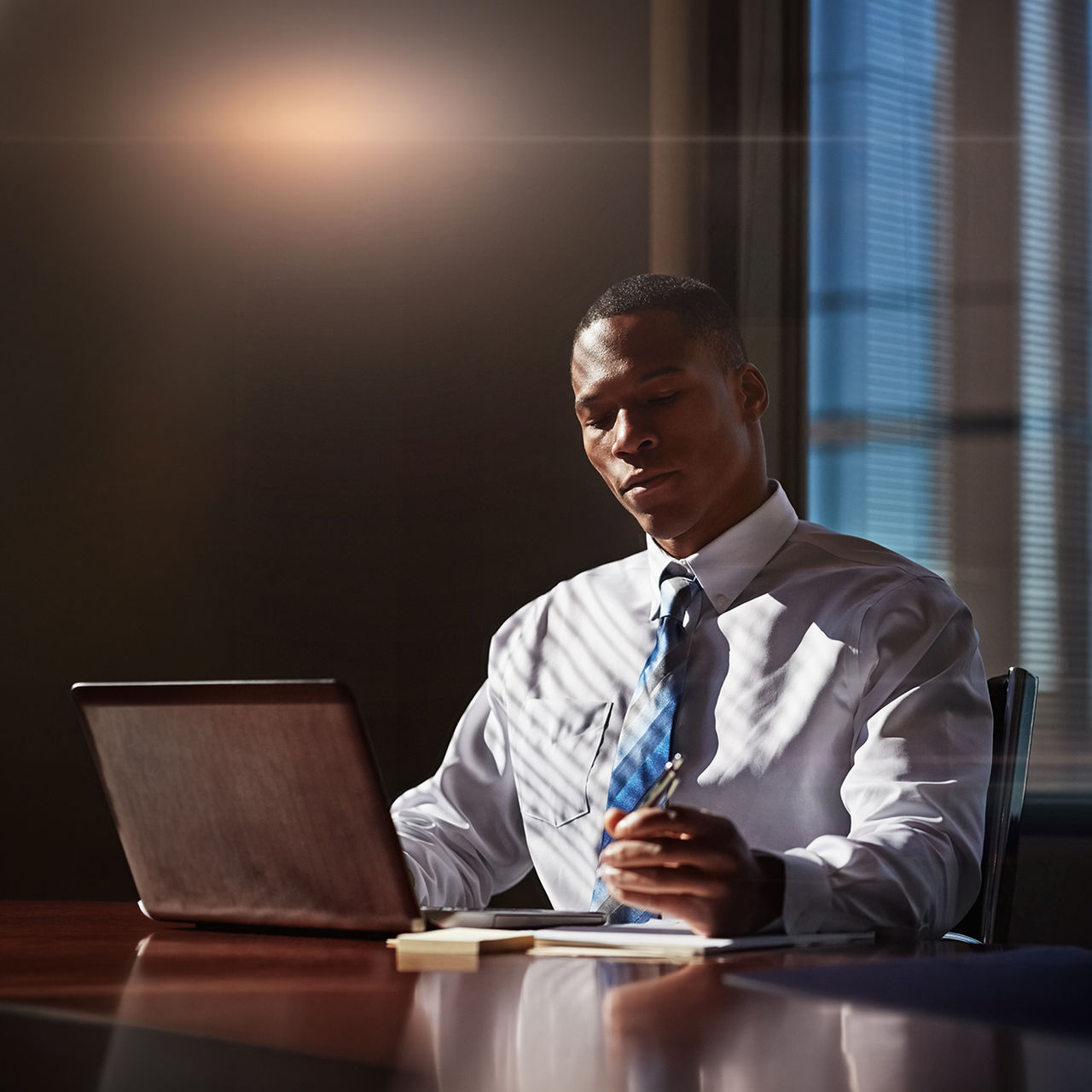 Attorney, notes or black man at firm with laptop, legal research or argument draft for trial report. Space, writing or lawyer with technology, case review or evidence proposal for court record