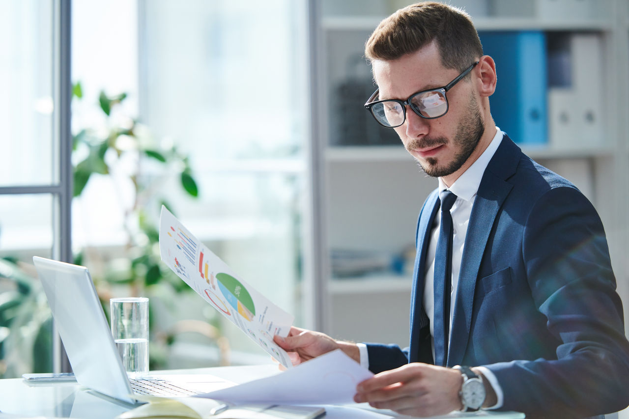 Office workers looking at business analytics on a big presentation board